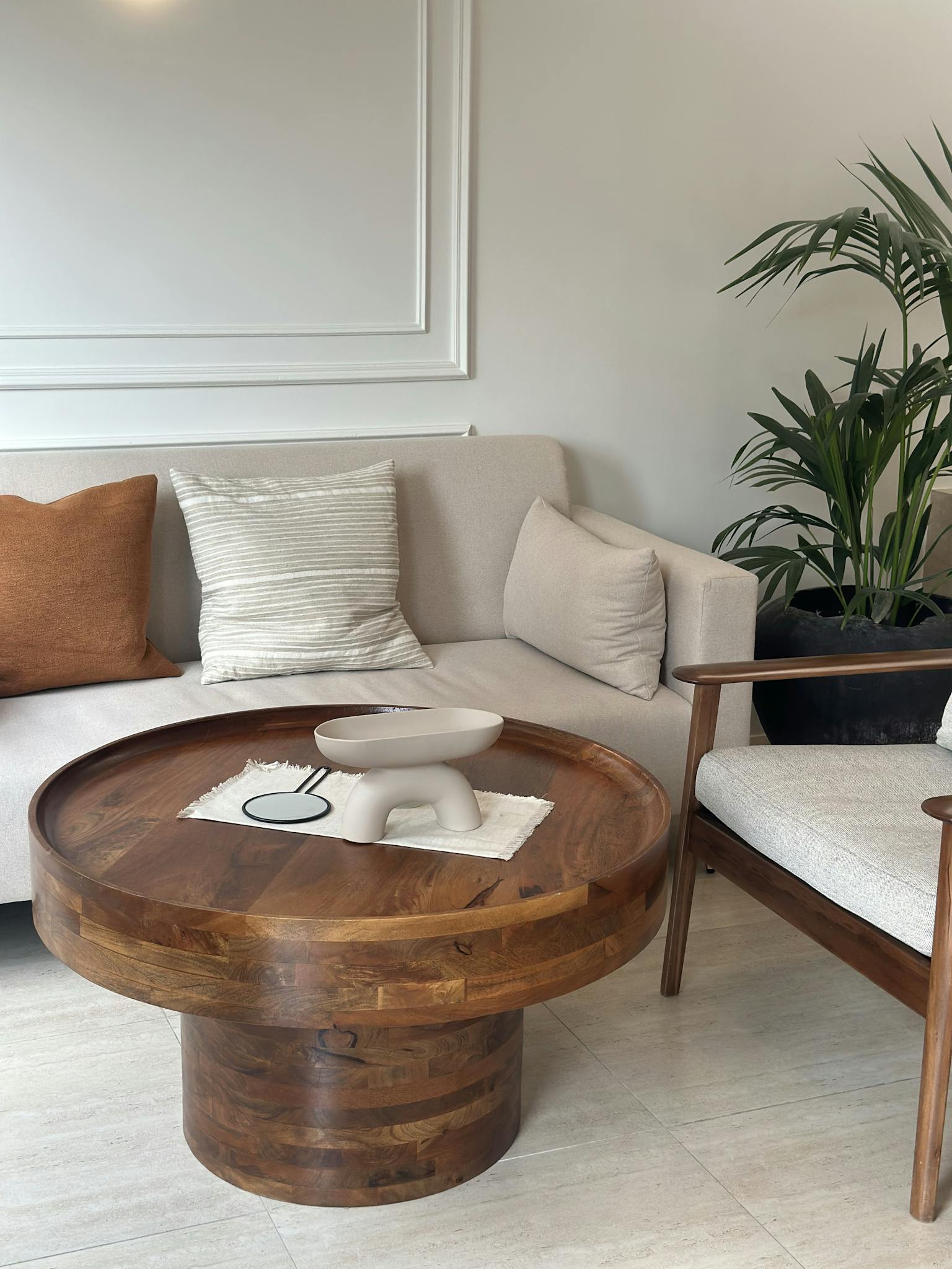 A modern living room setup featuring a wooden coffee table and cozy beige sofa.