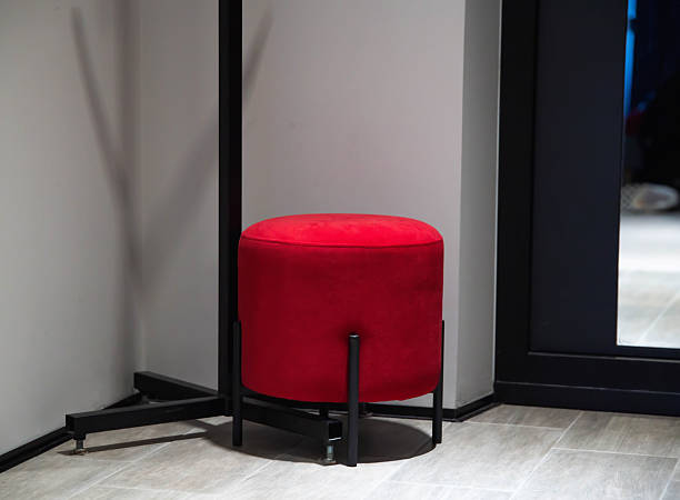 Modern red pouf in hallway corner for sitting, furniture